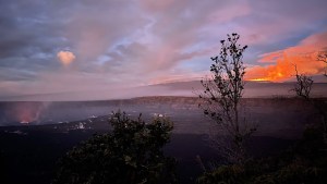 El lago de lava del volcán Kilauea, a la izquierda, y un magnífico resplandor de Mauna Loa, arriba a la derecha, iluminan el cielo de la mañana.