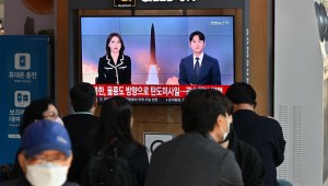 La gente mira una pantalla de televisión que muestra una transmisión de noticias con imágenes de archivo de una prueba de misiles de Corea del Norte, en una estación de tren en Seúl el 2 de noviembre de 2022.