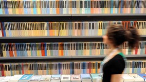 A woman walks in front of a bookshelf at Turin's book fair on May 08, 2008. Like its Parisian counterpart in March, the Turin fair is honouring Israel on the 60th anniversary of the Jewish state's creation, sparking fresh Muslim protests and boycott call. AFP PHOTO / GIUSEPPE CACACE (Photo credit should read GIUSEPPE CACACE/AFP via Getty Images)