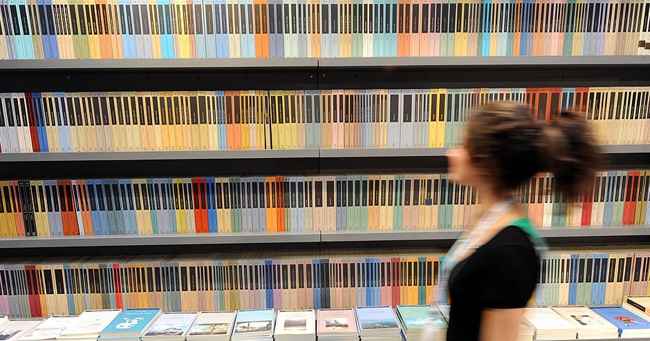 A woman walks in front of a bookshelf at Turin's book fair on May 08, 2008. Like its Parisian counterpart in March, the Turin fair is honouring Israel on the 60th anniversary of the Jewish state's creation, sparking fresh Muslim protests and boycott call. AFP PHOTO / GIUSEPPE CACACE (Photo credit should read GIUSEPPE CACACE/AFP via Getty Images)
