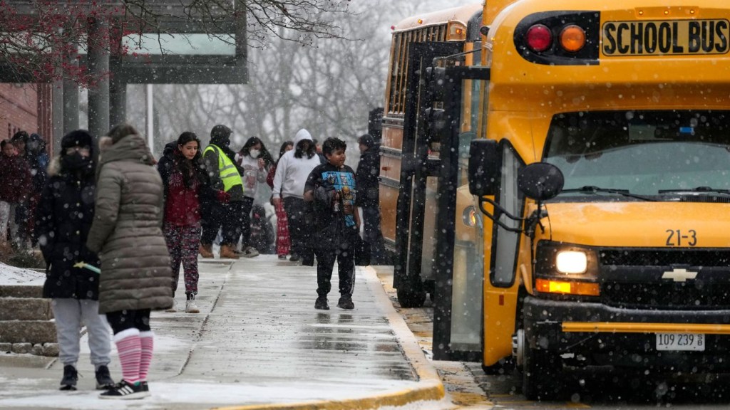 Alumnos caminan hacia los autobuses escolares después de la salida anticipada en una escuela secundaria en Wheeling, Illinois, el 22 de diciembre. (Crédito: Nam Y. Huh/AP)