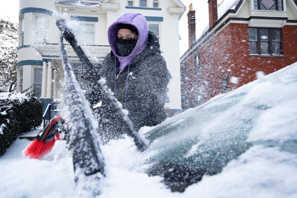 Amanda Kelly limpia la nieve y el hielo de su auto el viernes 23 de diciembre en Columbus, Ohio. (Crédito: Joseph Scheller/Columbus Dispatch/USA Today Network)