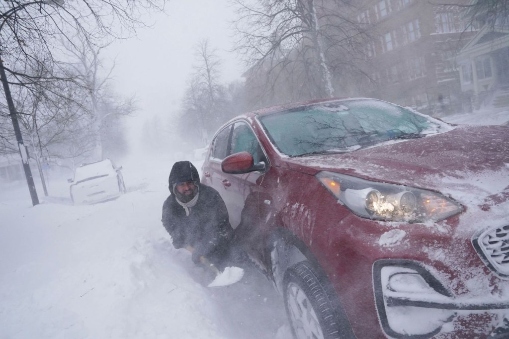 Un hombre trata de desenterrar su automóvil después de que se quedara atascado en un montón de nieve a una manzana de su casa en Buffalo, el sábado 24 de diciembre. (Crédito: Derek Gee/The Buffalo News vía AP)