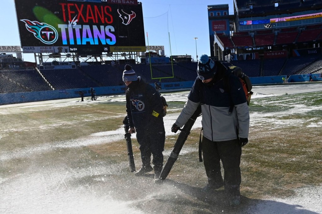 Empleados del estadio despejan el campo del Nissan Stadium de Nashville antes del partido entre Titans y Texans del 24 de diciembre. (Crédito: Mark Zaleski/AP)