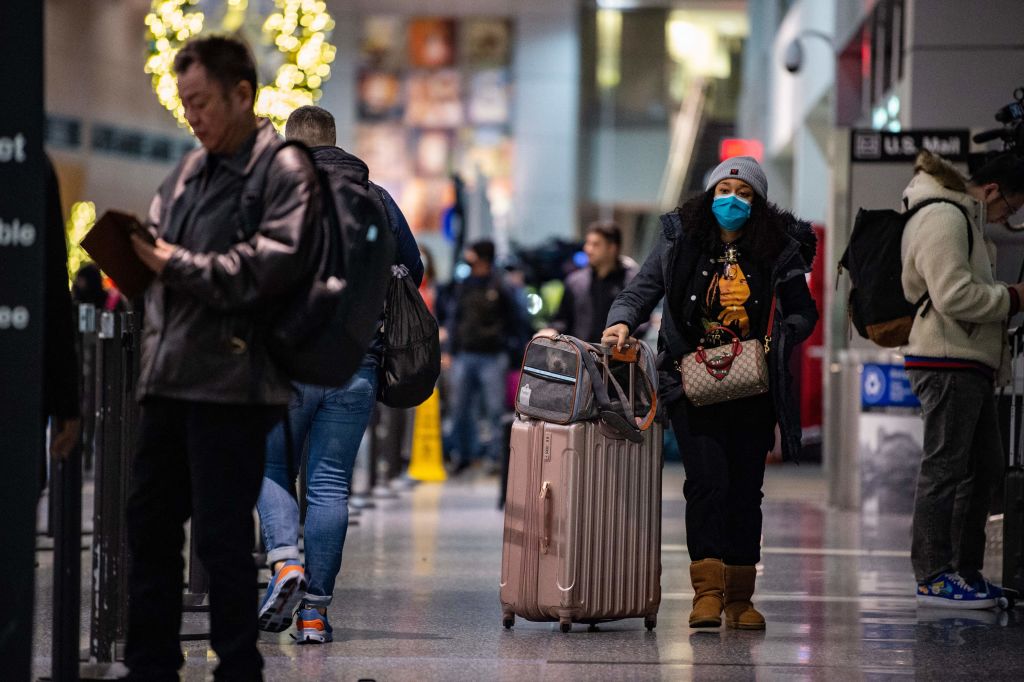Los viajeros se abren camino a través de la Terminal A del Aeropuerto Internacional Logan en Boston, Massachusetts, el 23 de diciembre de 2022. (Foto de JOSEPH PREZIOSO/AFP vía Getty Images)