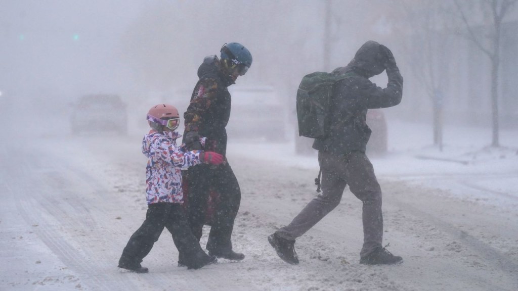 A family walks down Elmwood Avenue in Buffalo, New York, on Friday.  (Credit: Derek Gee/The Buffalo News/AP)