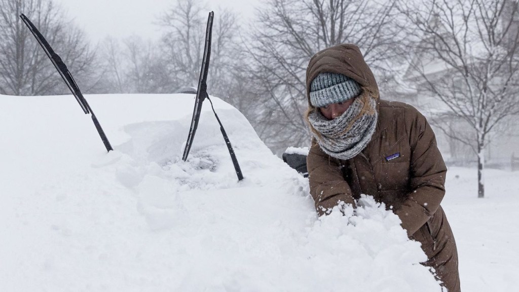 A Buffalo, New York, resident clears snow from her car on Saturday.  (Credit: Jalen Wright/EPA-EFE/Shutterstock)