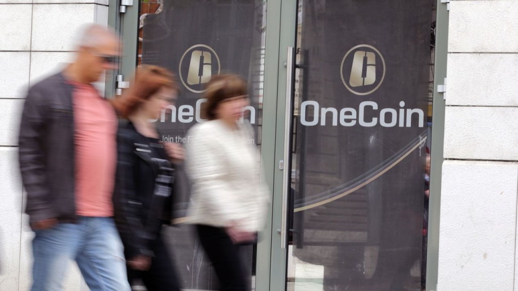Varias personas pasan por delante de las oficinas de OneCoin en Sofía (Bulgaria). Las autoridades federales afirman que la criptomoneda se creó para estafar a los inversores. (Crédito: Cylonphoto/iStock Editorial/Getty Images)
