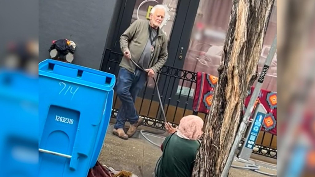 A San Francisco businessman sprays a homeless woman with water