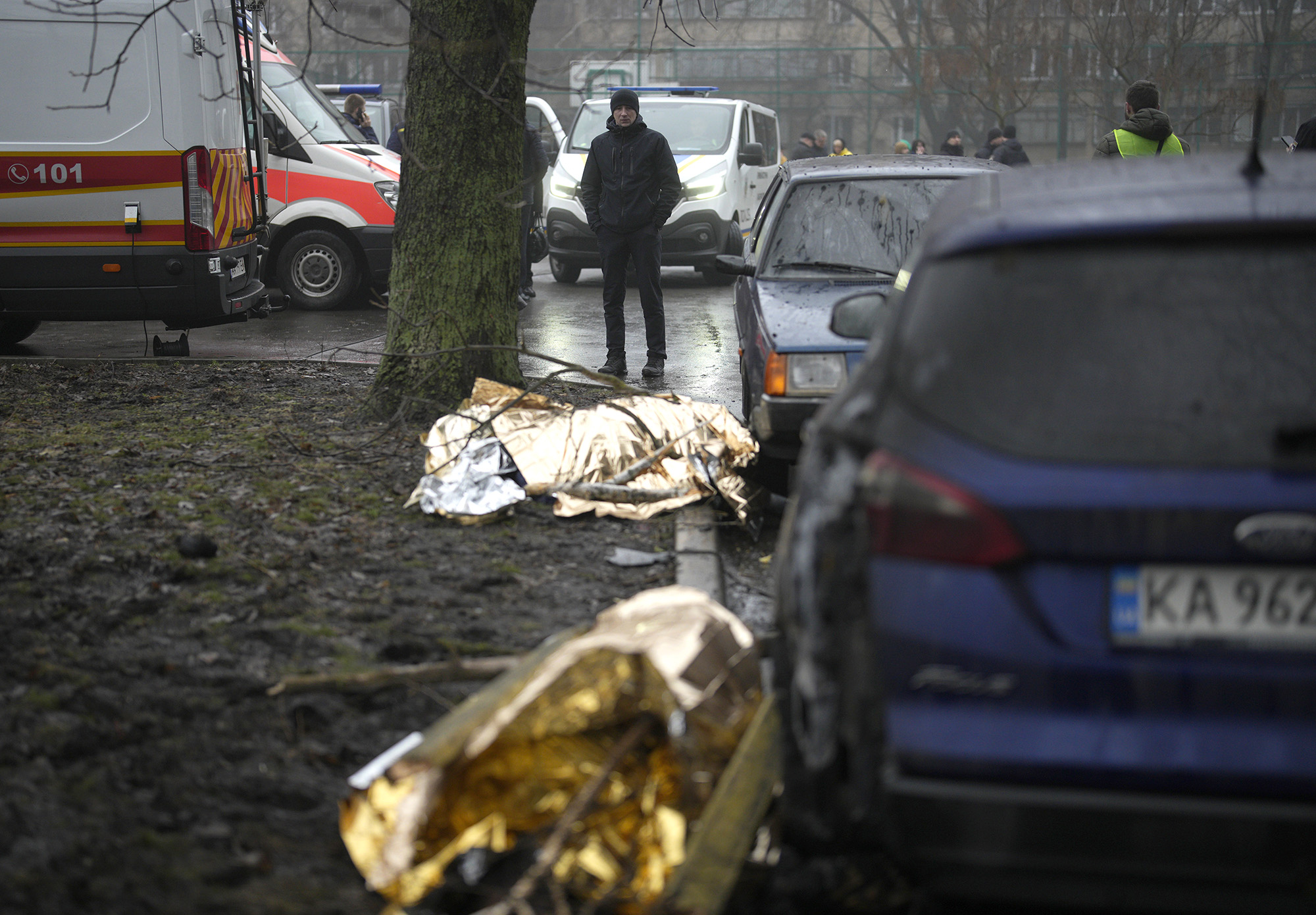 Cuerpos cubiertos en el suelo en el lugar donde se estrelló un helicóptero en Brovary, a las afueras de Kyiv, Ucrania, el 18 de enero. (Daniel Cole/AP)