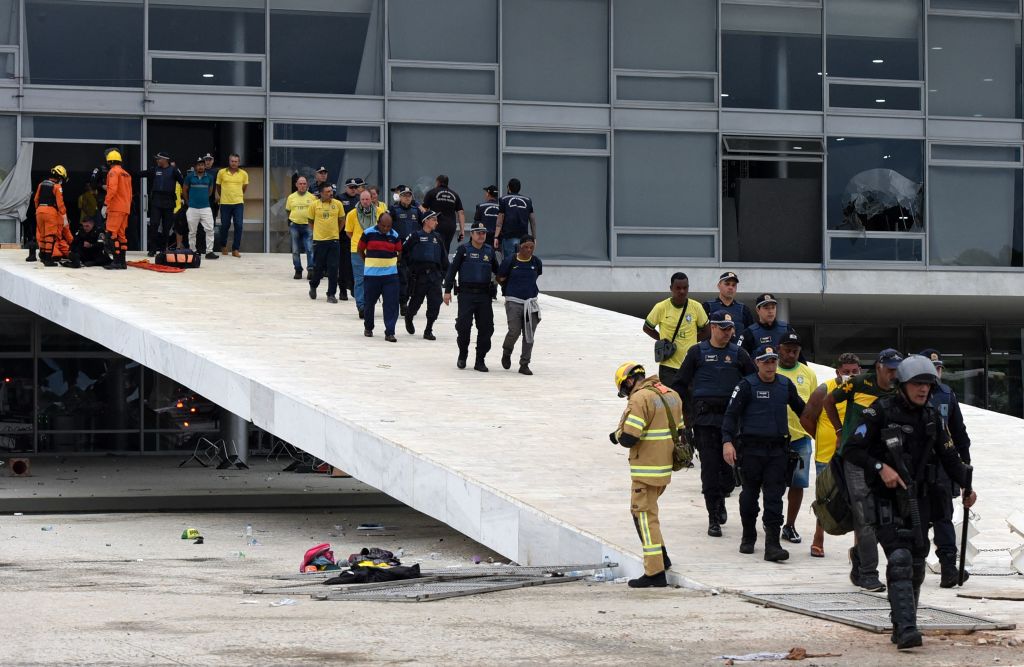 Las fuerzas de seguridad detienen a simpatizantes del expresidente Jair Bolsonaro que invadieron el Palacio Presidencial de Planalto, en Brasilia, el 8 de enero de 2023. (TON MOLINA/AFP vía Getty Images)