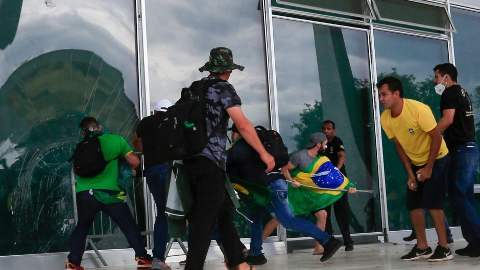 Simpatizantes de Bolsonaro rompen una ventana mientras invaden el Palacio Presidencial de Planalto. (SERGIO LIMA/AFP vía Getty Images)