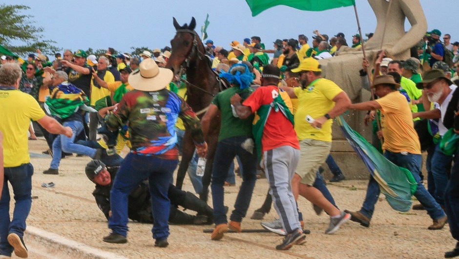 Un agente de la Policía Militar cae de su caballo durante los enfrentamientos con simpatizantes de Bolsonaro tras una invasión al Palacio Presidencial de Planalto. (SERGIO LIMA/AFP vía Getty Images)