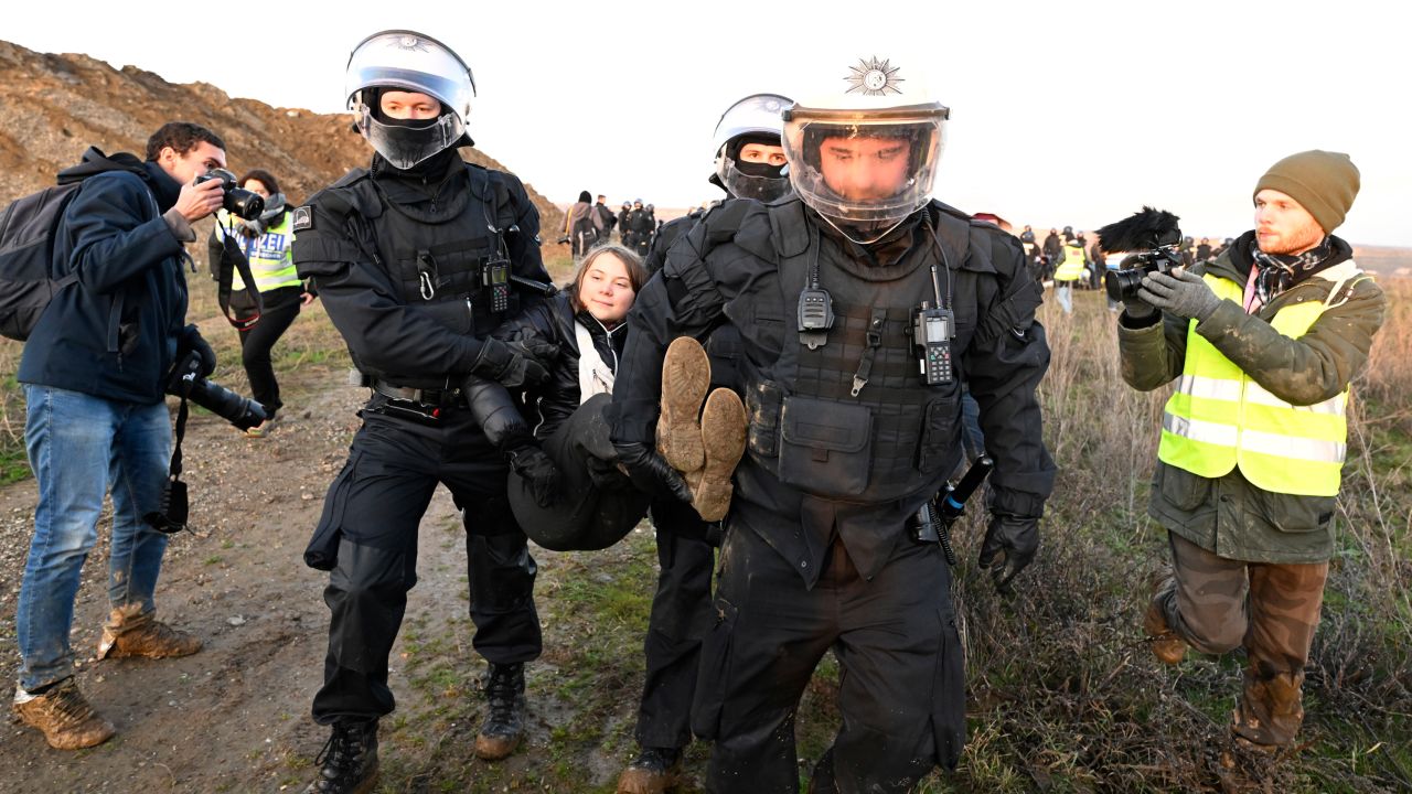 Image of police detaining Greta Thunberg.