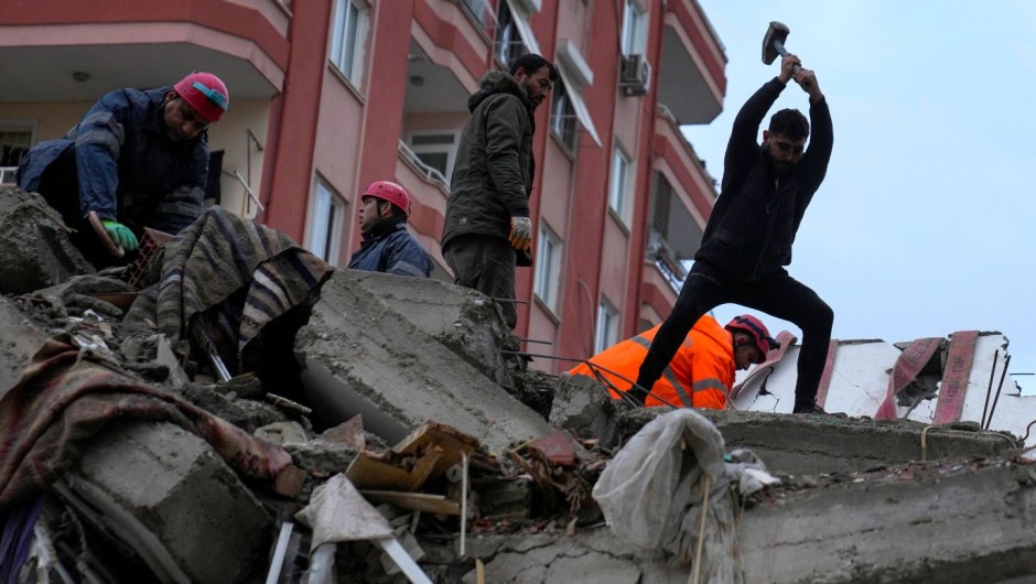 Varias personas buscan supervivientes en un edificio destruido en Adana, Turquía, el 6 de febrero. (Khalil Hamra/AP)