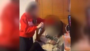 Captura de pantalla de un video que circuló en internet este martes en el que se ve a una estudiante de Filadelfia usando pintura negra en aerosol en la cara de otra. (Crédito: obtenida por CNN)