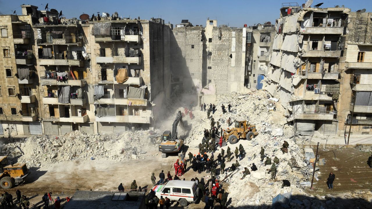 Los soldados sirios observan cómo los rescatistas usan maquinaria pesada para examinar los escombros de un edificio derrumbado en la ciudad norteña de Alepo. AFP/Getty Images