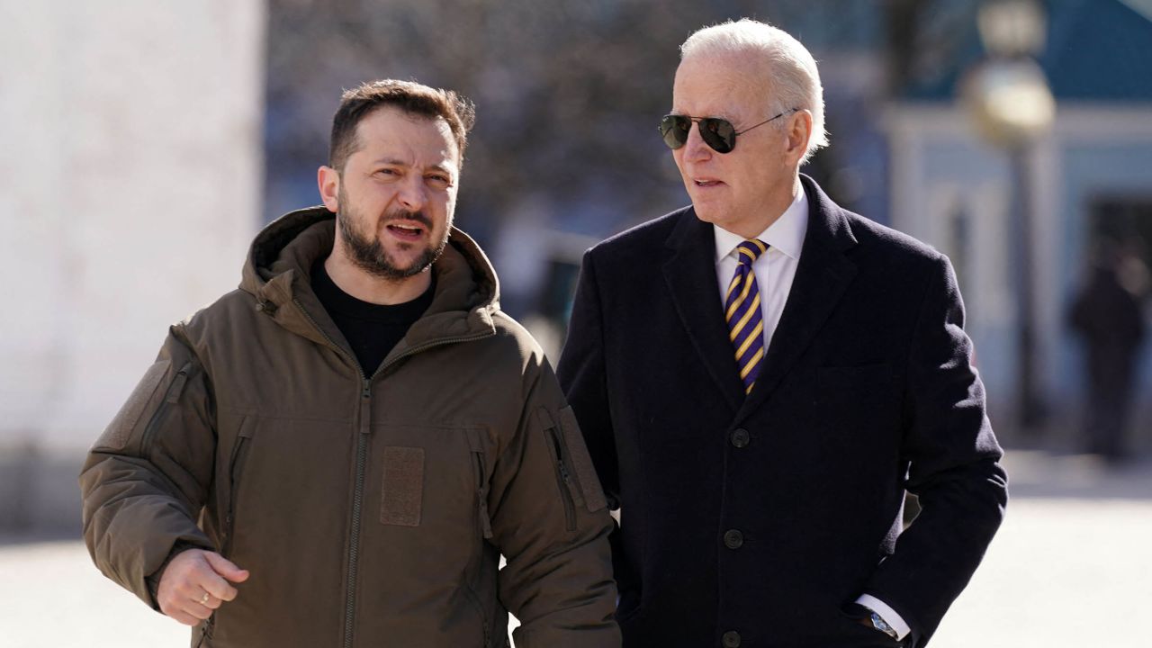 El presidente de Estados Unidos, Joe Biden (a la derecha), camina junto al presidente de Ucrania, Volodymyr Zelensky, a su llegada para una visita en Kyiv el 20 de febrero de 2023. (Crédito: Dimitar Dilkoff/AFP/Getty Images)