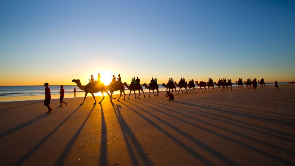 Sunset camel rides are one of the main attractions at Cable Beach in Broome, Australia.  (Credit: timothylui1105/Moment RF/Getty Images)