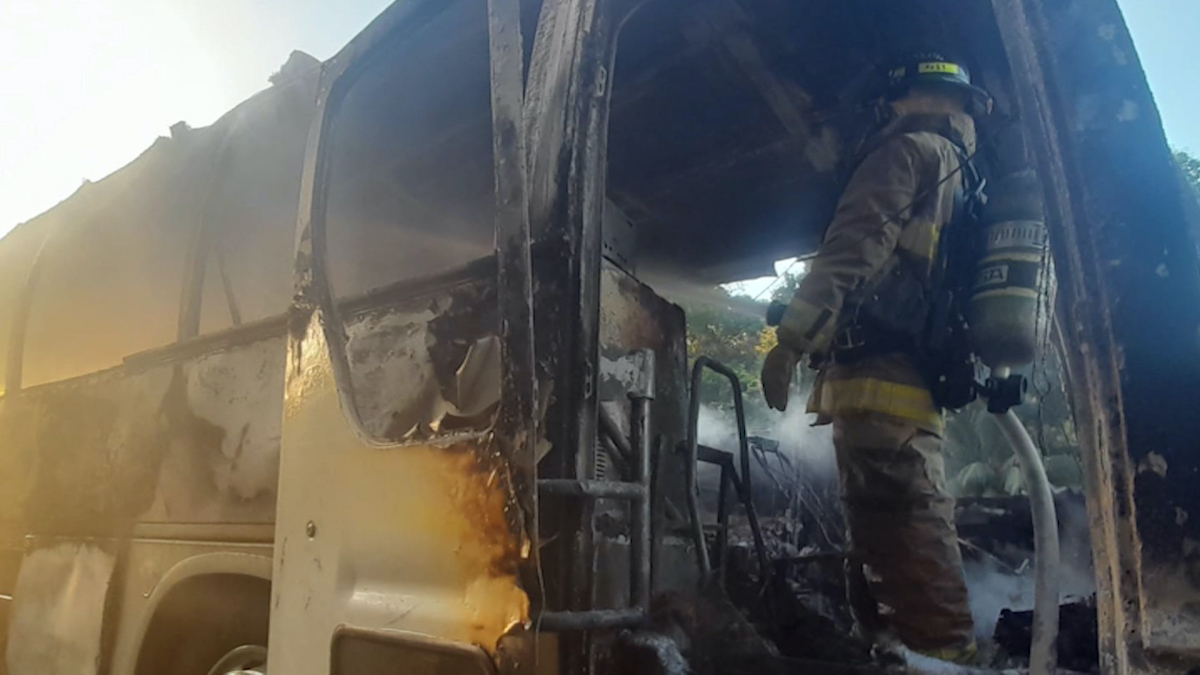 Bomberos apagando el incendio de un bus de migrantes en Panamá. 