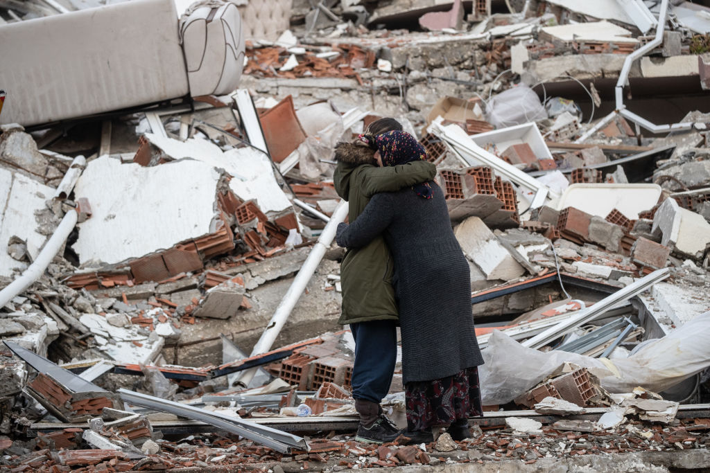 Dos mujeres se abrazan ante un edificio derrumbado Hatay, Turkía (Photo by Burak Kara/Getty Images)