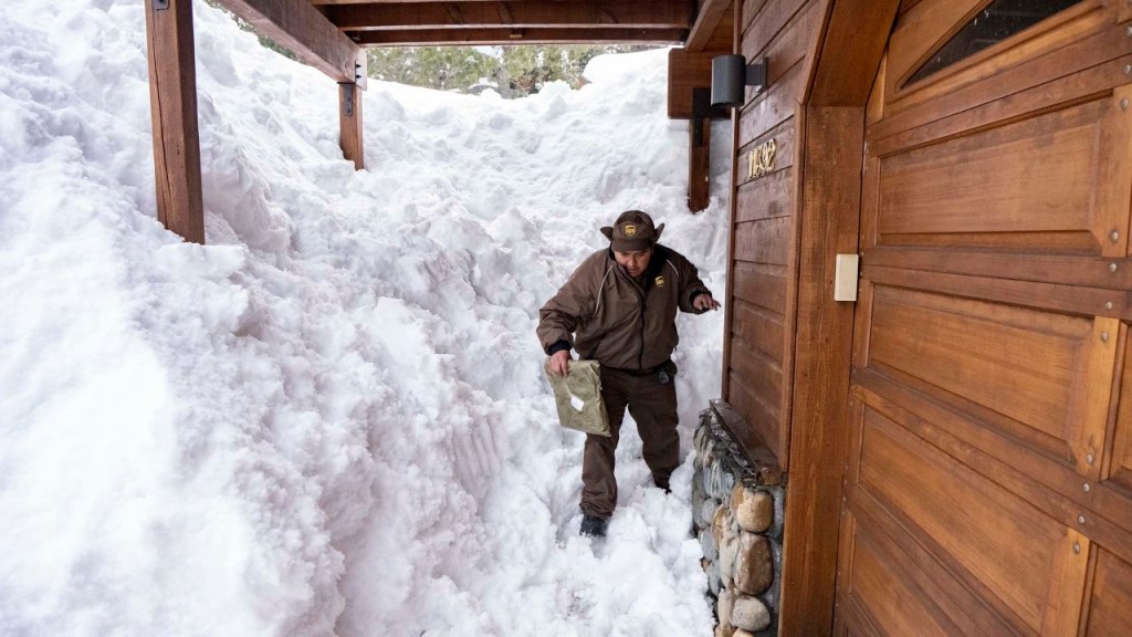 Juan Hernandez, repartidor de UPS, entrega un paquete en una casa cubierta de nieve en Truckee, California, el viernes. (Crédito: Josh Edelson/The Washington Post/Getty Images)