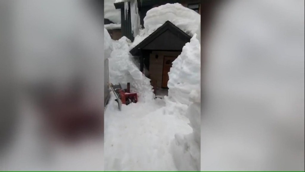 Residente de California camina a través de un túnel de nieve para llegar a su casa