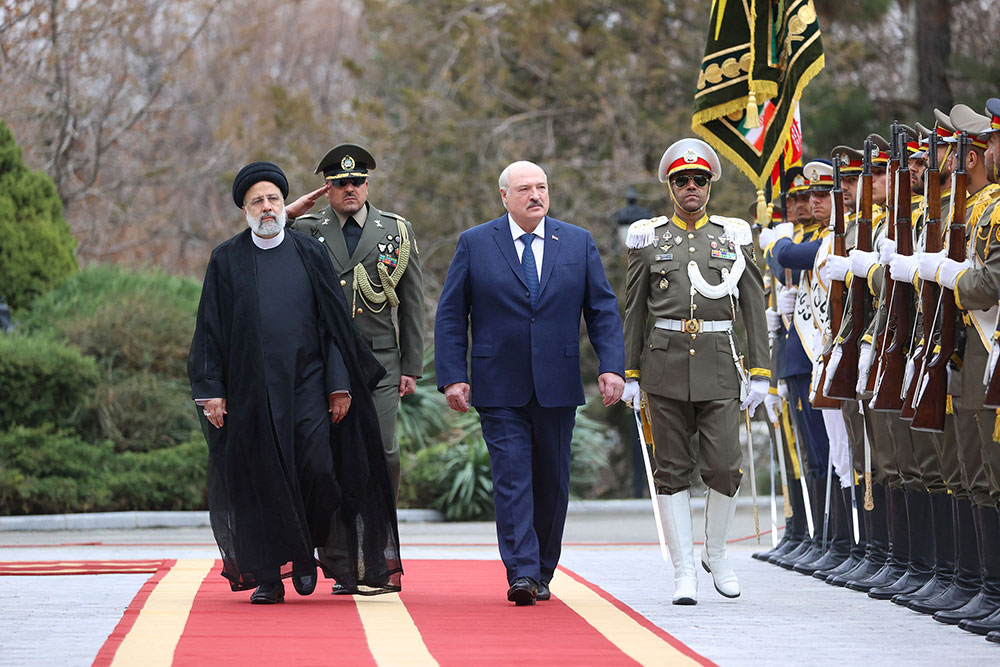 El presidente iraní, Ebrahim Raisi, a la izquierda, camina con el presidente de Bielorrusia, Alexander Lukashenko, durante una ceremonia de bienvenida en Teherán, Irán, el 13 de marzo. (BelTA/Handout/Reuters)