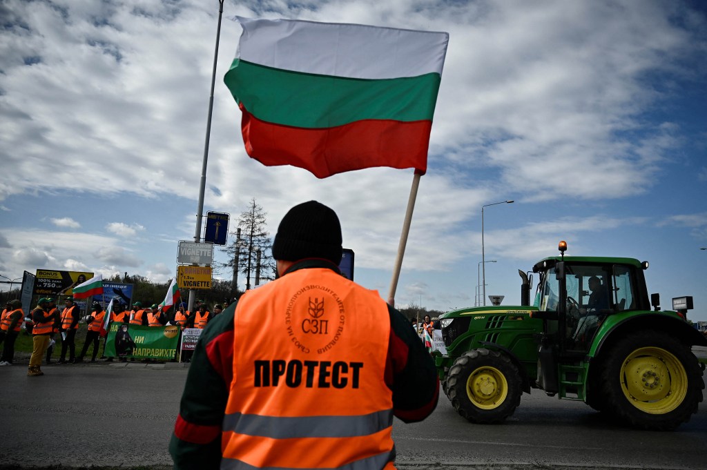 Un agricultor ondea la bandera de Bulgaria durante un intento de bloquear los camiones que cruzan la frontera entre Bulgaria y Rumania en protesta por la importación libre de impuestos de granos procedentes de Ucrania a la Unión Europea, el 29 de marzo. (Crédito: Nikolay Doychinov/AFP/ Getty Images)
