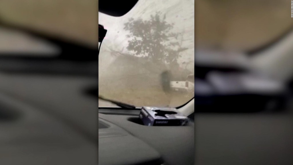 Mira a un hombre salir de un tornado dentro de una camioneta