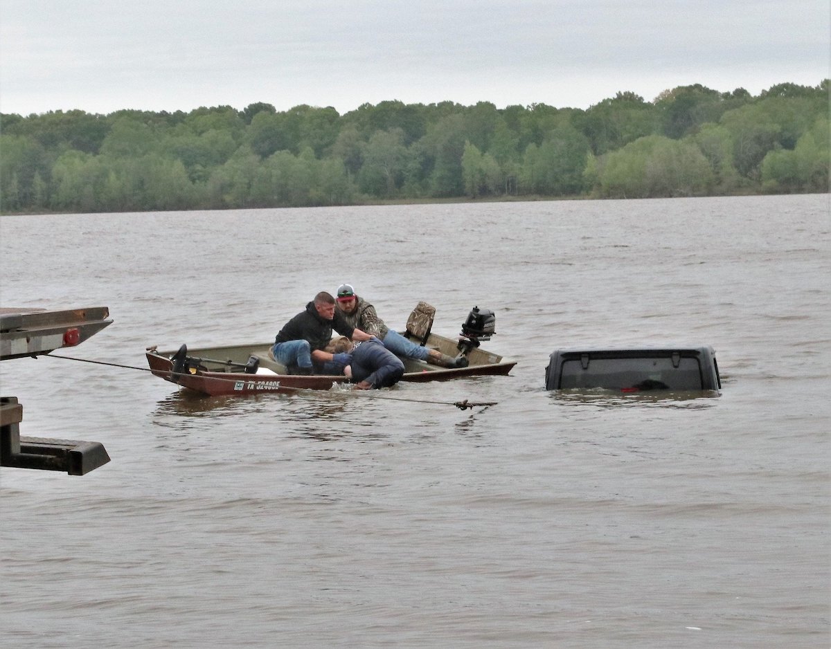 Un pescador y el empleado de la grúa ayudaron a la mujer desde el Jeep y la colocaron en el bote donde la llevaron a tierra.