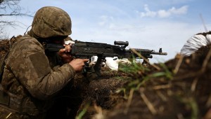 Un soldado ucraniano dispara un arma desde una trinchera en la línea del frente en Bakhmut, Ucrania, el 5 de abril. (Crédito: Kai Pfaffenbach/Reuters)