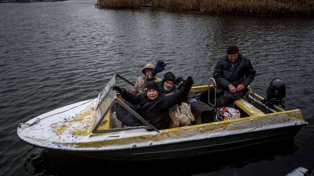 Esta fotografía tomada el 6 de diciembre de 2022 muestra a habitantes sentados en un bote durante su evacuación de un pueblo de vacaciones de la isla Potyomkinskyi en el río Dnipro, cerca de Jersón, en medio de la invasión rusa de Ucrania. (Foto: ANATOLII STEPANOV/AFP vía Getty Images)