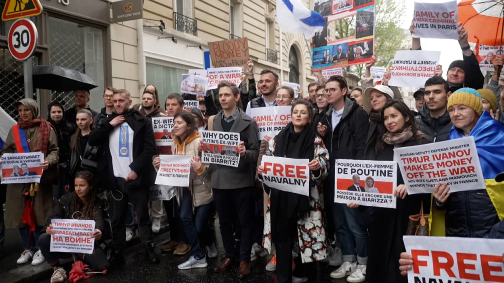 Manifestantes con pancartas frente a un edificio de apartamentos de lujo en París el 23 de abril, donde Svetlana Maniovich parece tener un apartamento.  (Crédito: CNN)