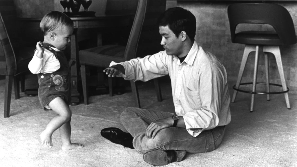Brandon Lee aprende algunos movimientos de artes marciales de su padre, Bruce Lee, en una foto de 1970. (Cortesía: Everett Collection)