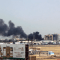 El 15 de abril de 2023, en medio de los enfrentamientos en la capital sudanesa, una densa humareda se cierne sobre los edificios cercanos al aeropuerto de Jartum. (Crédito: AFP/Getty Images)