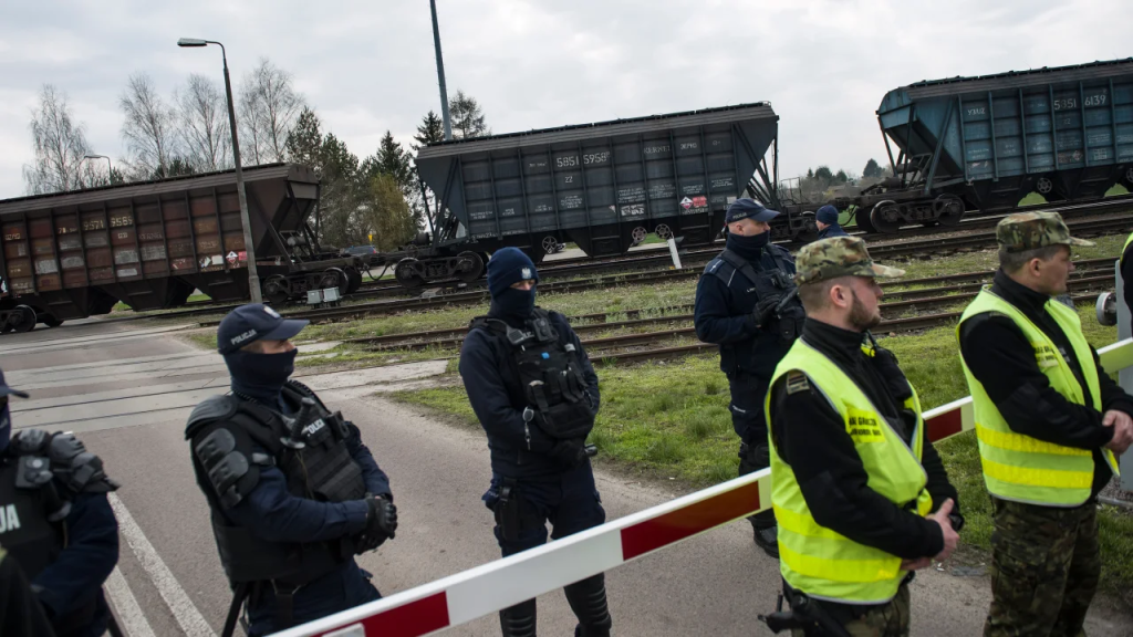 La policía y los guardias fronterizos protegen un tren que transporta grano ucraniano en el cruce ferroviario de vía ancha en Hrubieszow, Polonia, el 12 de abril de 2023. (Crédito: Attila Husejnow/SOPA Images/LightRocket/Getty Images)