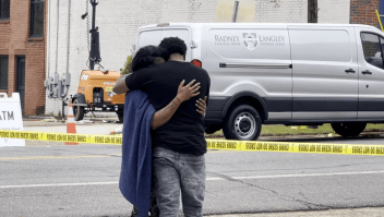 Personas de luto lloran cerca del lugar del tiroteo masivo en el que dispararon a más de una docena de adolescentes. (Crédito: WTVM)
