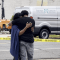 Personas de luto lloran cerca del lugar del tiroteo masivo en el que dispararon a más de una docena de adolescentes. (Crédito: WTVM)