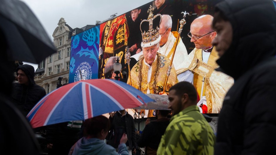 La gente en Piccadilly Circus de Londres pasa junto a una pantalla gigante que muestra una imagen del rey durante la ceremonia de coronación. (Foto: Sarah Tilotta/CNN)