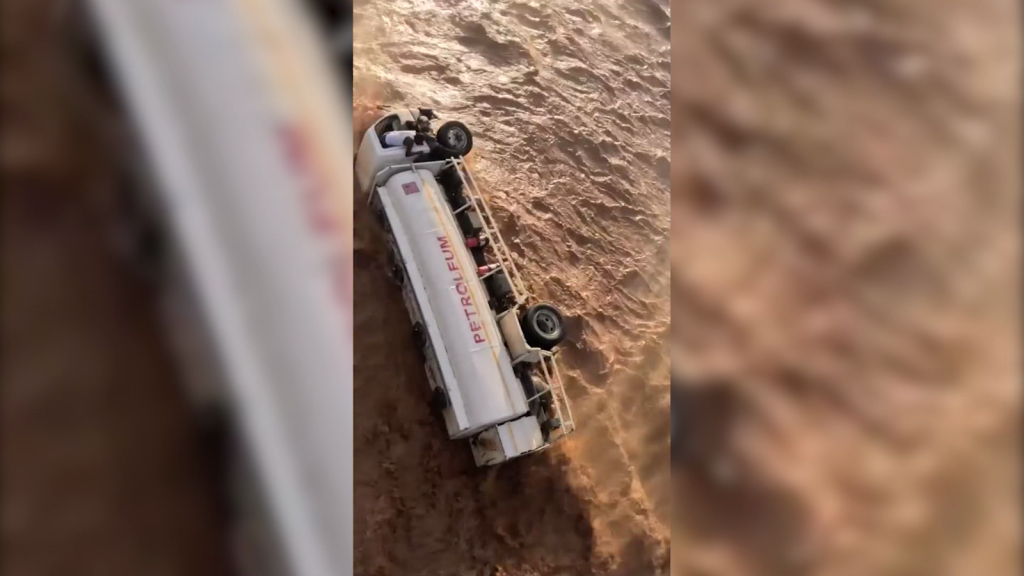 Helicopter flies near a truck to rescue the driver