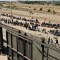 Una imagen aérea muestra a migrantes esperando junto al muro fronterizo para entregarse a los agentes de la Patrulla Fronteriza del CBP para la tramitación de solicitudes de inmigración y asilo tras cruzar el río Grande hacia EE.UU. en El Paso, Texas, el 10 de mayo. (Foto: Patrick T. Fallon/AFP/Getty Images)