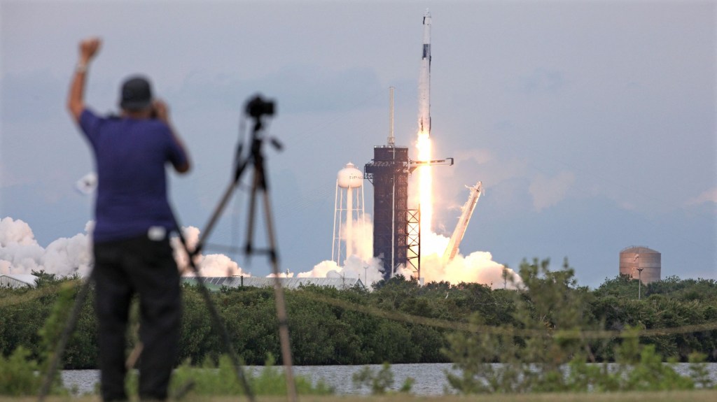 Un fotógrafo aplaude el despegue del cohete Falcon 9 de SpaceX que transporta a la tripulación de la misión AX-2 desde la plataforma 39A del Centro Espacial Kennedy de la NASA, en Florida, el 21 de mayo de 2023. (Foto: GREGG NEWTON/AFP vía Getty Images)