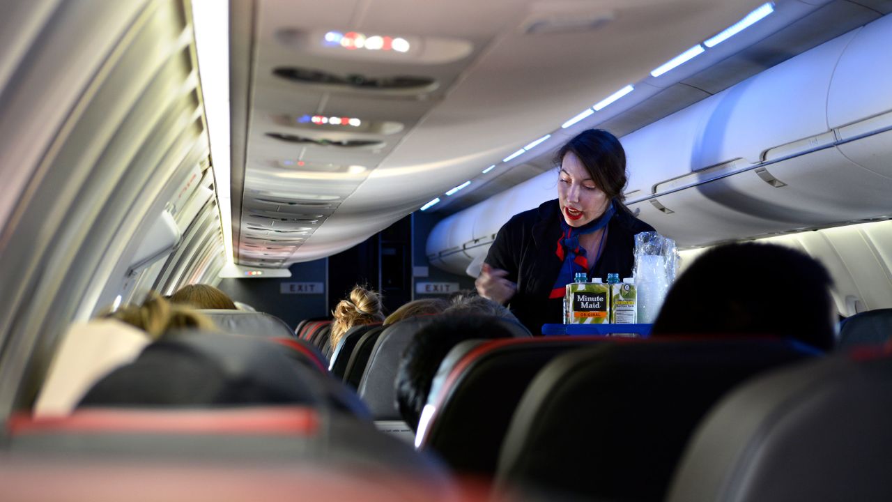 Una azafata sirve bebidas a los pasajeros a bordo de un vuelo de American Airlines desde el Aeropuerto Internacional de Dallas/Fort Worth. (Roberto Alejandro/Getty Images)