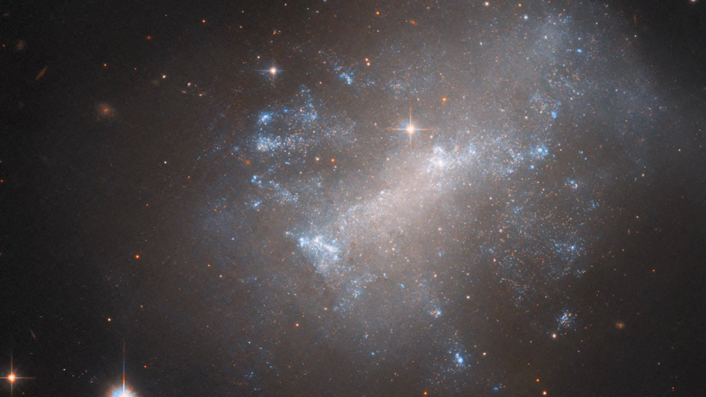 La NASA compara imágenes de una galaxia irregular ondulante