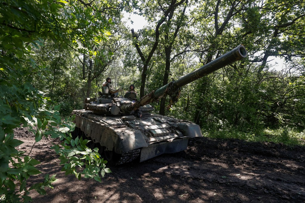 Militares ucranianos de la 30ª Brigada Mecanizada Separada Kostiantyn Ostrozkyi viajan en un tanque de batalla principal T-80 capturado anteriormente a las tropas rusas, en una posición cerca de la ciudad de Bakhmut en la región de Donetsk, Ucrania, el 19 de junio. (Foto: Serhii Nuzhnenko/Radio Free Europe/Radio Liberty/Reuters)