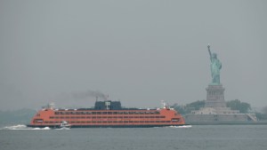 El ferry de Staten Island pasa junto a la Estatua de la Libertad este martes por la mañana cuando el humo de los incendios forestales canadienses se asentó sobre la ciudad de Nueva York. (Spencer Platt/Getty Images)