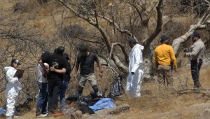 Expertos forenses trabajan con varias bolsas de restos humanos extraídas del fondo de un barranco por un helicóptero (Crédito: Ulises Ruiz/AFP/Getty Images)