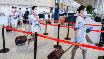 Auxiliares de vuelo de Hainan Airlines se preparan para embarcar en un avión en el aeropuerto internacional de Haikou Meilan el 17 de marzo en Haikou, China.