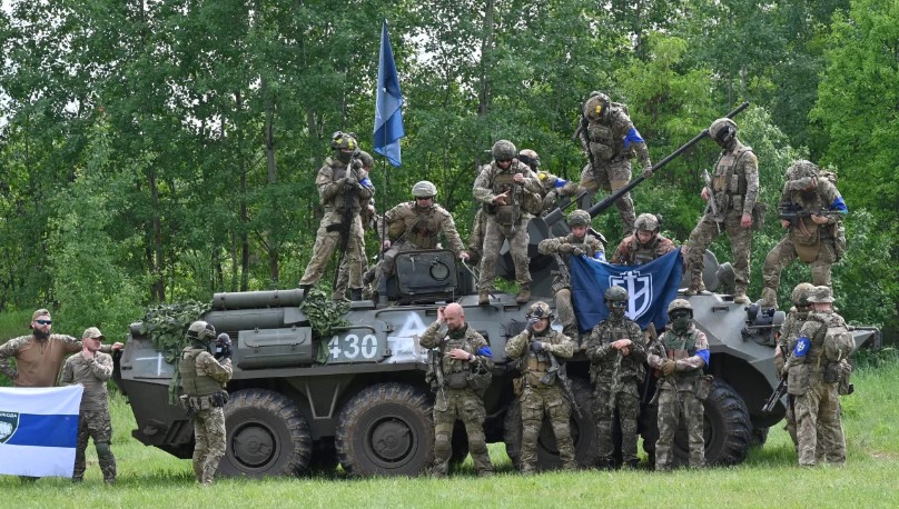 Combatientes del Cuerpo de Voluntarios Rusos y el grupo aliado Legión de la Libertad Rusa se paran junto a un vehículo blindado de transporte de personal incautado el 24 de mayo de 2023. (Crédito: Sergey Bobok/AFP/Getty Images)